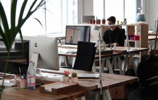 Empty desk with someone working at a second desk in the background